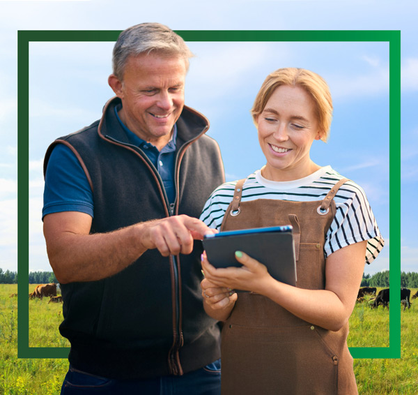 Two farmers in a field looking at information on an iPad